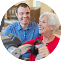 female patient wearing a bright red top and red lipstick smiling while exercising